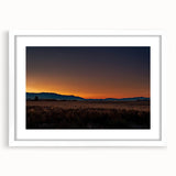 Abstract art print of Montana scenery in muted earth tones on a white matted frame, suitable for dining room decor.