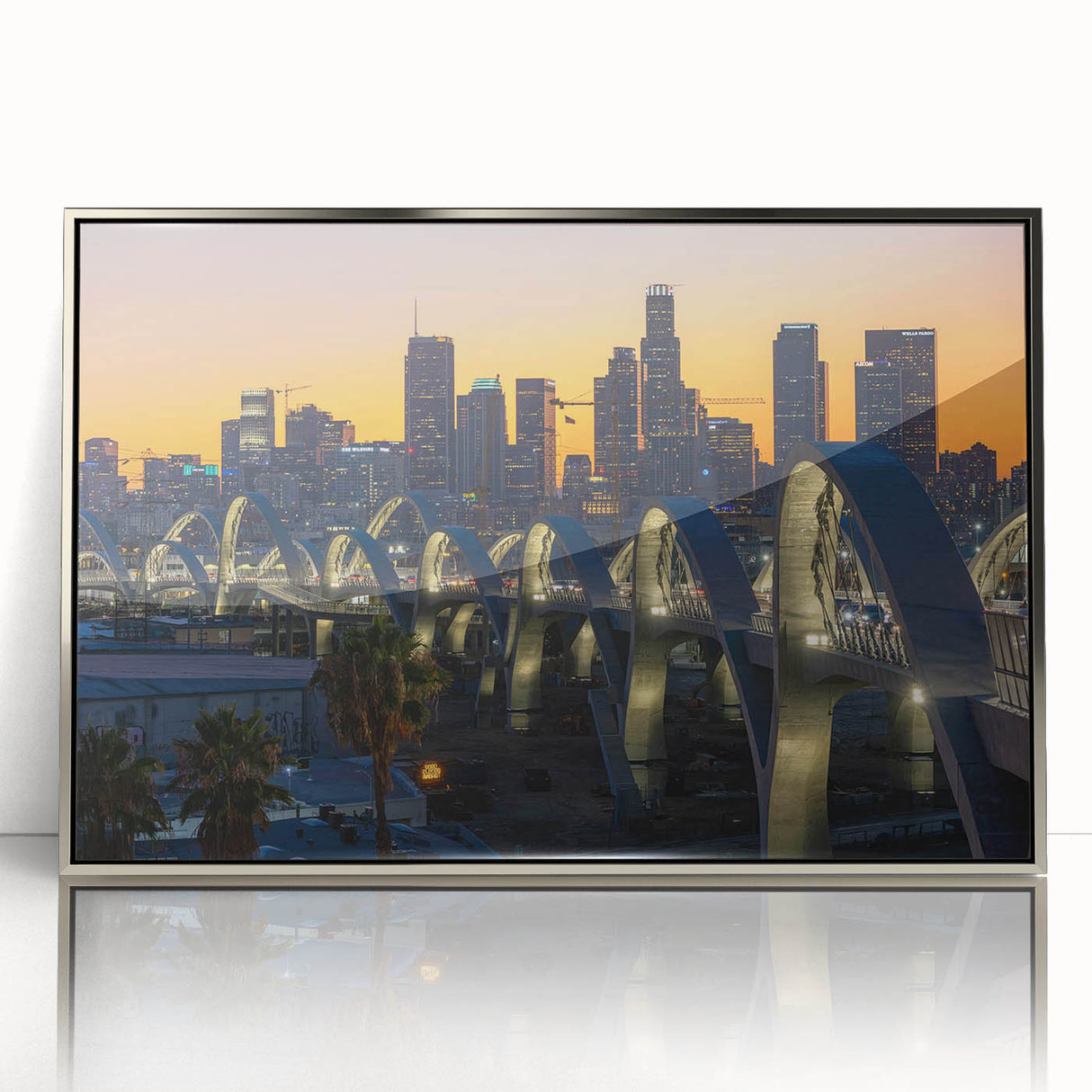 Mid-century modernist art depicting Los Angeles skyline in muted gray and blue tones on a silver-framed acrylic print.