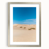Framed artwork showcasing a serene landscape of sand dunes, elegantly presented with a silver mat. Ideal for enhancing home decor with a touch of nature's beauty.