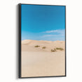 Framed canvas art depicting serene desert dunes in warm tones, elegantly set in a sleek black frame, perfect for modern home decor. Ideal for nature enthusiasts.
