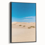 Framed canvas art depicting serene desert dunes in warm tones, elegantly set in a sleek black frame, perfect for modern home decor. Ideal for nature enthusiasts.