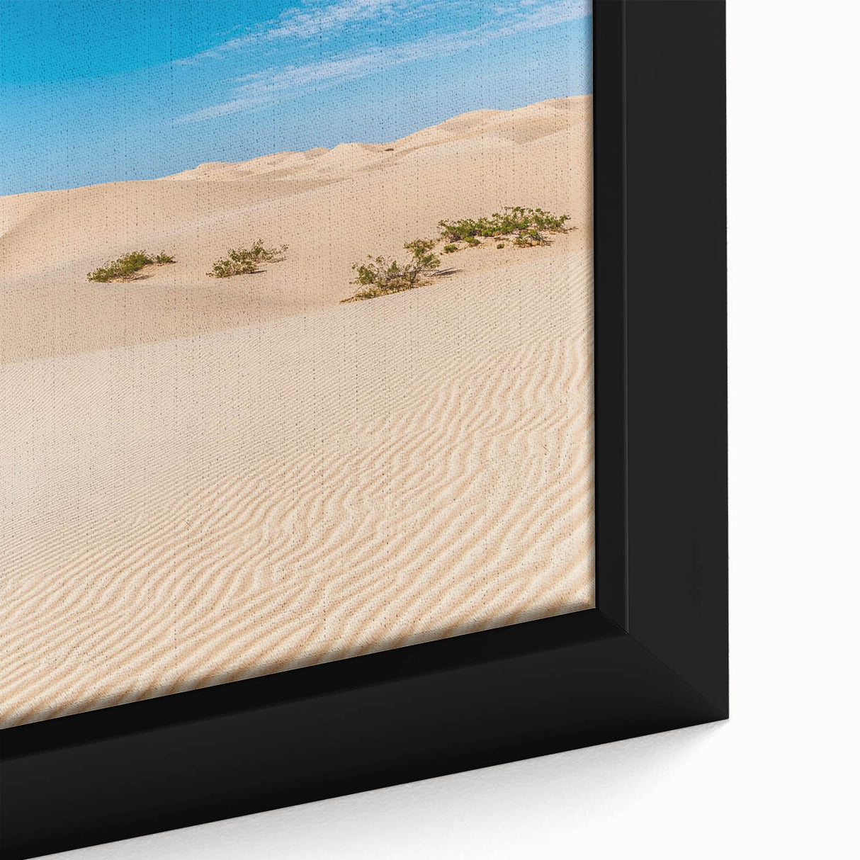 Close-up of a framed canvas depicting serene sand dunes at sunset, showcasing warm hues of orange and yellow, perfect for modern home decor.