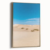 Framed canvas artwork showcasing a serene desert landscape with soft golden dunes, elegantly displayed from the side, ideal for modern home decor.