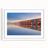 Abstract art print of a Middle Eastern scenery in muted earth tones on a white matted frame, suitable for dining room decor.