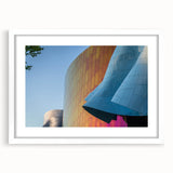 Abstract art print of Seattle skyline in muted blue and gray tones on a framed white canvas.
