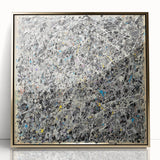 Framed abstract art piece featuring colorful splatters in vibrant hues of gold, blue, and red, set against a sleek acrylic background, perfect for modern decor.