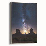 Framed canvas artwork showcasing a desert landscape with vibrant hues of orange and red, elegantly displayed with a sleek silver frame, perfect for modern decor.