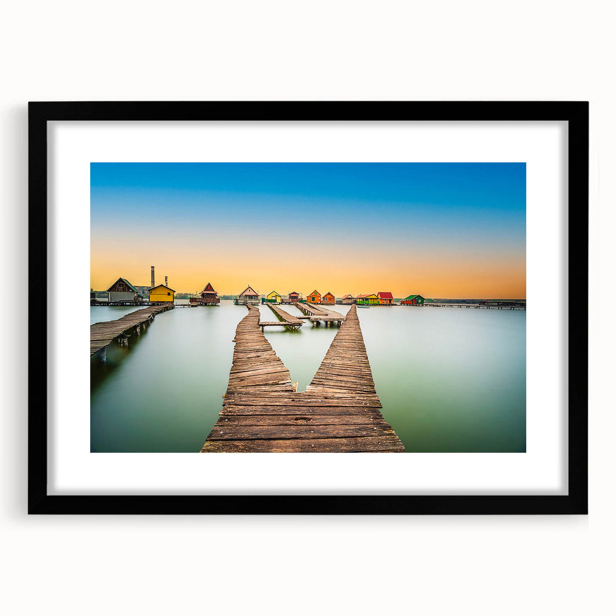 Abstract art print of a colorful European scenery in vibrant hues, textured on a large black-framed canvas.