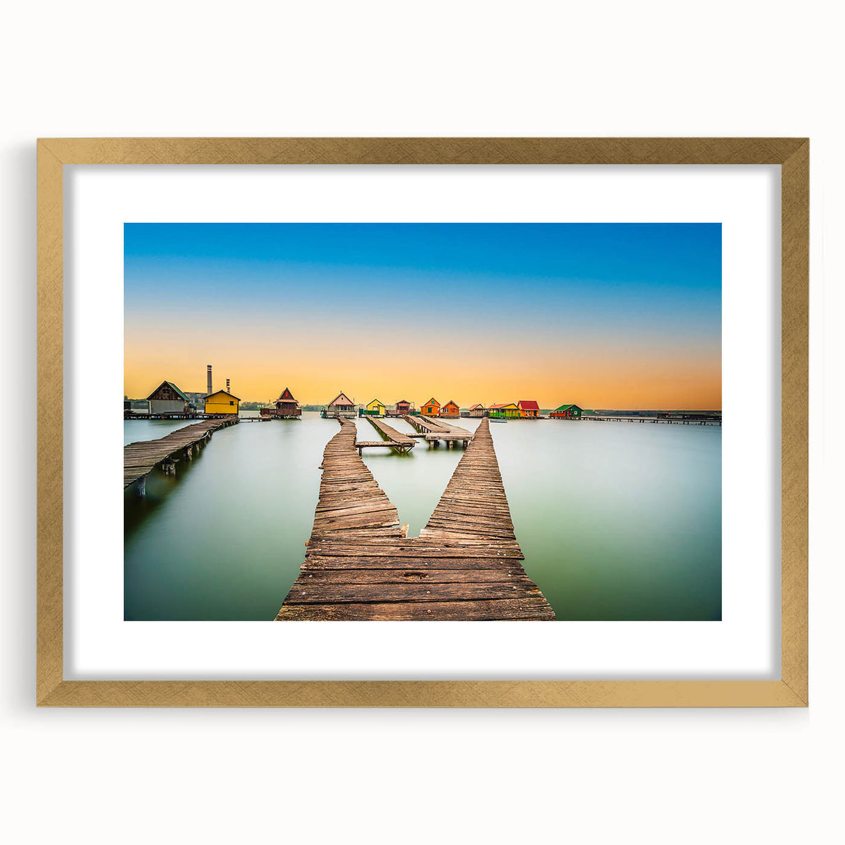 Abstract art print of a European scenery in muted gold and green tones, framed with a gold mat.