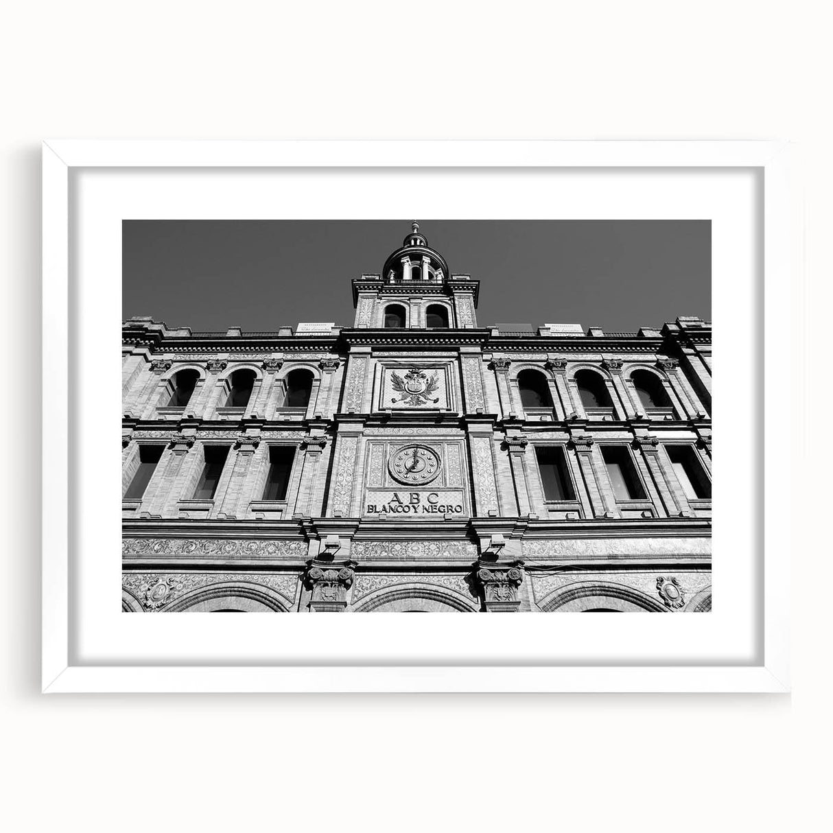 Abstract art print of Madrid skyline in muted blue and orange tones on a framed white mat, ideal for dining room decor.