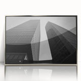 Large art print of a European cityscape in muted gray and blue tones, framed in silver acrylic.