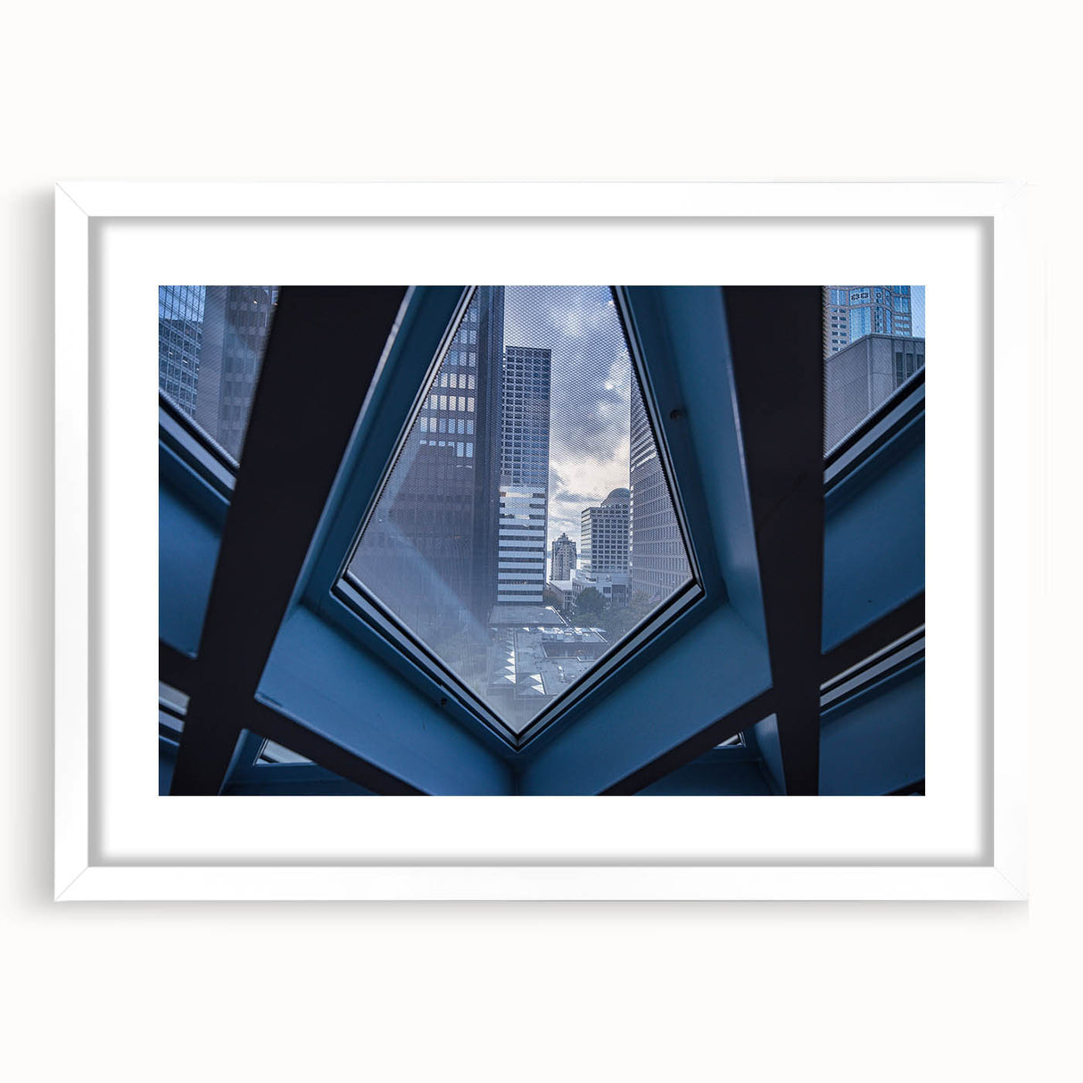 Abstract art print of Seattle skyline in muted gray tones on a framed white mat, suitable for bedroom or dining room decor.