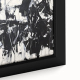 Close-up of a framed abstract canvas featuring vibrant splatter designs in shades of blue, orange, and yellow, perfect for modern home decor. The textured surface adds depth and character to any living space, making it an eye-catching art piece.