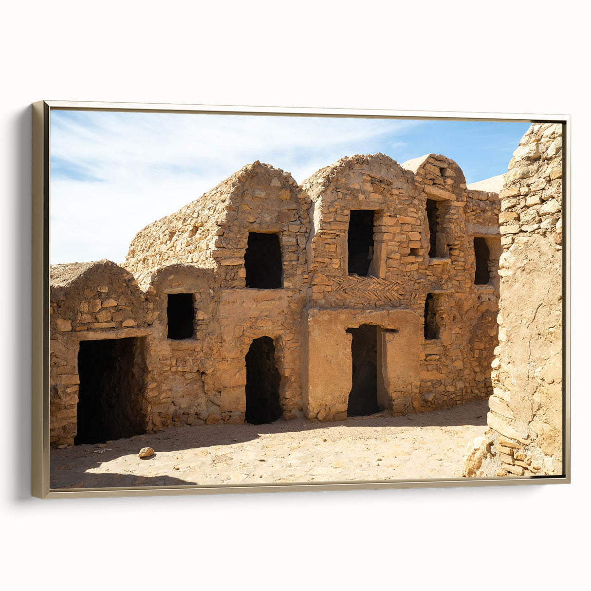 Framed canvas of a Moroccan landscape in vintage poster style, featuring black and gold tones, ideal for bedroom wall art.
