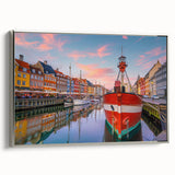 Framed canvas featuring a vintage poster art style landscape of a European town with colorful buildings and a black border.