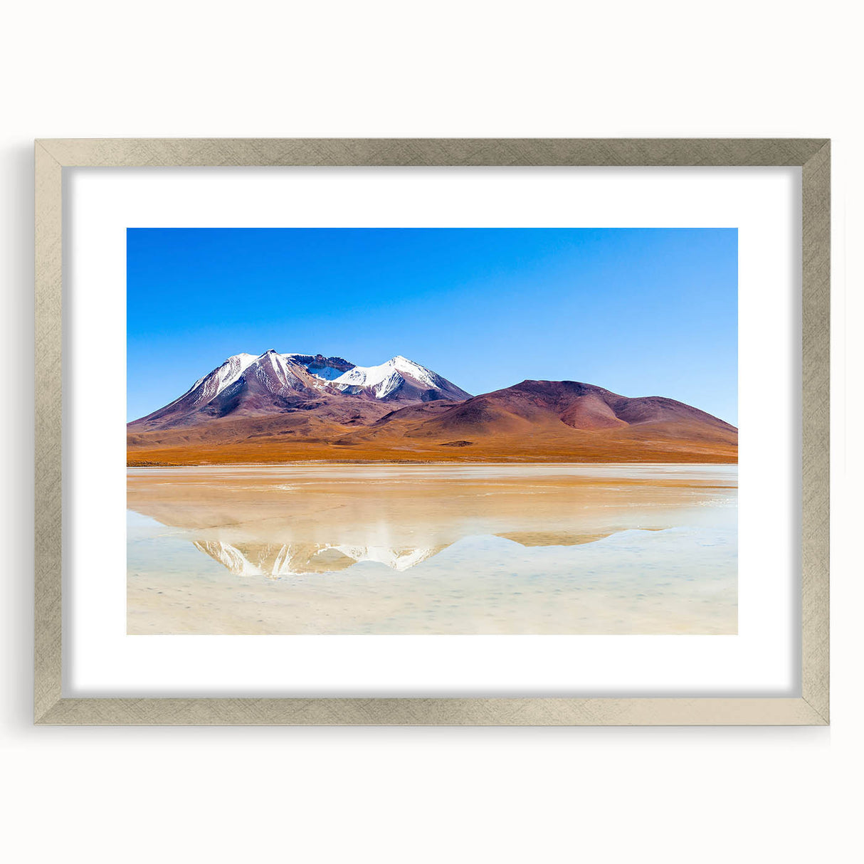 Textured abstract art print depicting a Bolivian landscape in earthy tones, framed in silver, ideal for bedroom decor.