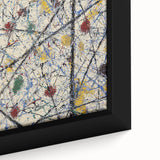 Close-up view of a framed abstract splatter art canvas, showcasing vibrant colors like blue, yellow, and red, ideal for modern home decor or gallery walls.