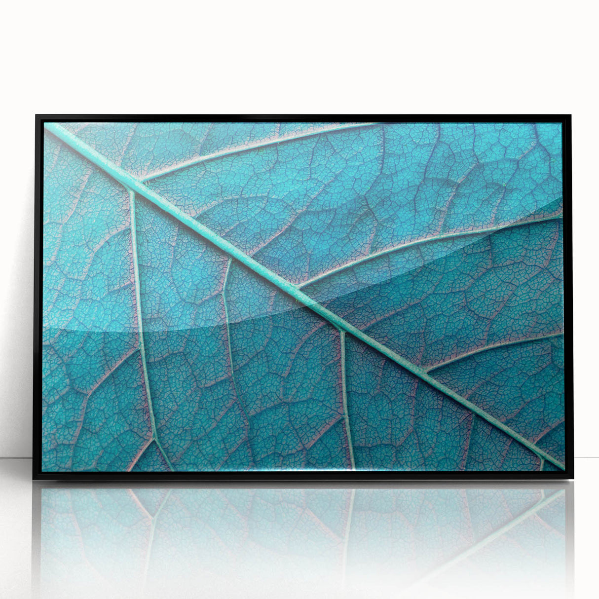 Large abstract wall art featuring close-up leaves in muted green tones on a framed acrylic.