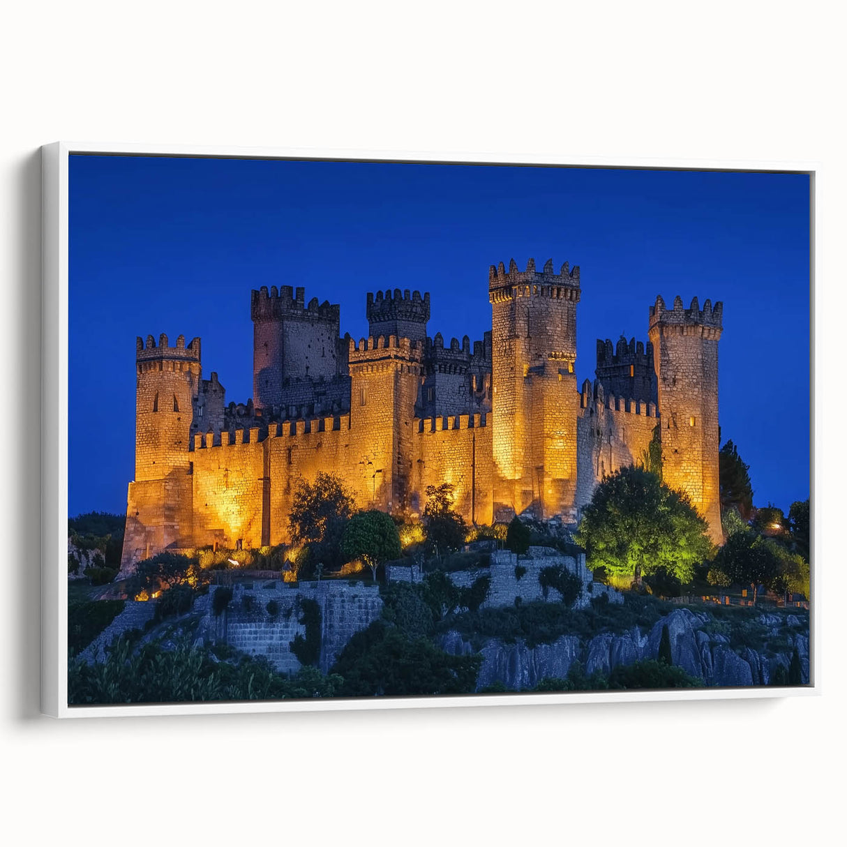 Framed canvas artwork showcasing a picturesque landscape with a medieval castle, featuring vibrant colors and intricate details, set against a white background for a modern aesthetic.