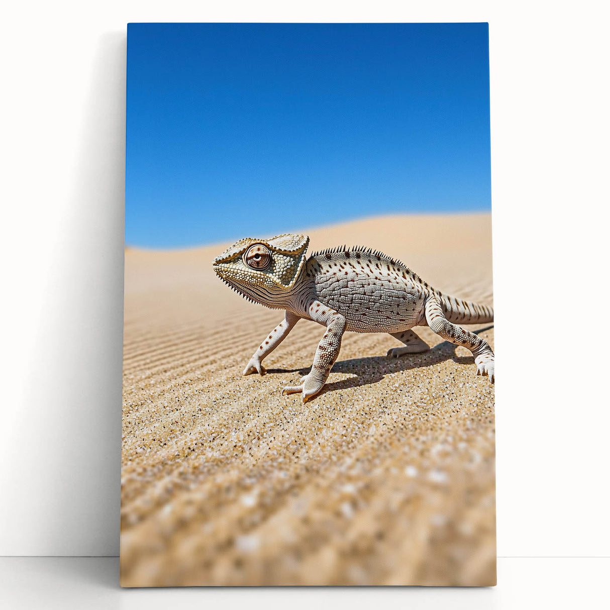Stretched canvas artwork depicting a vibrant desert landscape with warm hues of orange and yellow, leaning against a neutral wall, perfect for home decoration.
