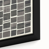 Close-up of a minimalist framed canvas artwork featuring abstract shapes in muted tones of beige and gray, showcasing its textured surface and refined details.