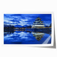 Rolled print showcasing a vibrant landscape with an intricately detailed castle, featuring lush greenery and a clear blue sky, packaged securely in a cardboard tube for safe shipping.