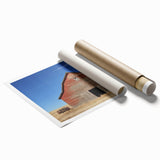 Rolled print showcasing a serene landscape of a rustic barn surrounded by lush greenery and vibrant sky, securely packaged in a protective cardboard tube for delivery.
