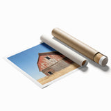 Rolled landscape art print showcasing a serene barn scene with vibrant colors and intricate details, securely packaged in a protective cardboard tube for shipping.