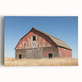 Stretched canvas print showcasing a vibrant landscape of a rustic barn set against a colorful sunset, ideal for farmhouse decor and nature enthusiasts.
