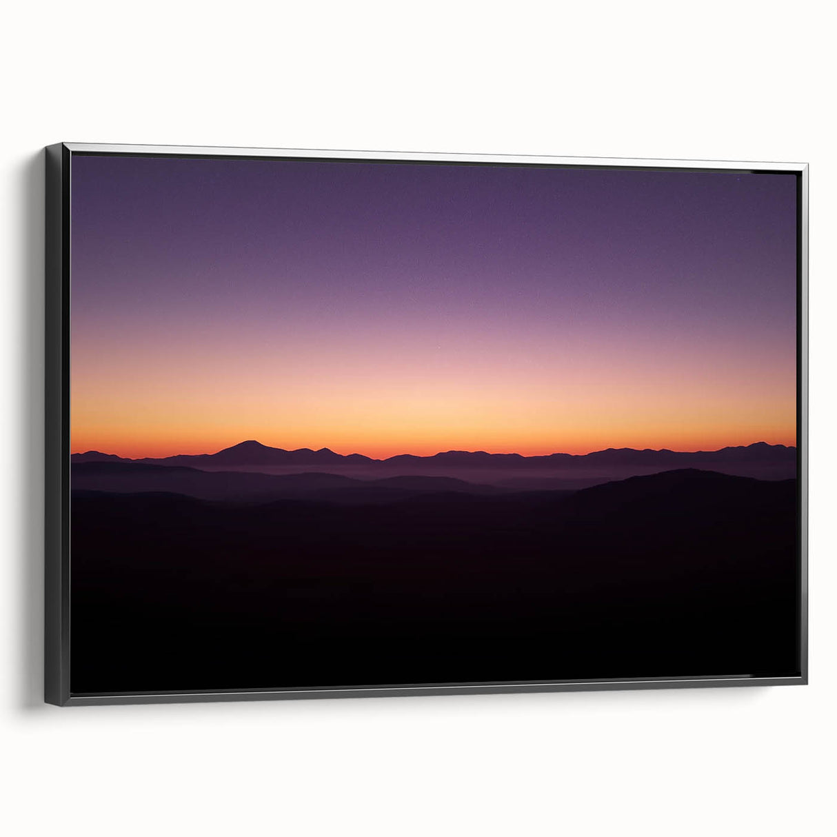 Framed canvas artwork depicting a serene desert landscape in warm tones, featuring cacti and mountains, presented in a sleek black frame, ideal for modern decor.