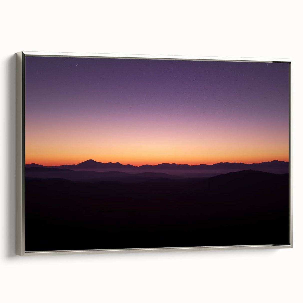 Framed canvas artwork depicting a serene desert landscape with warm tones and intricate details, featuring a sleek silver frame, ideal for home decor enhancement.