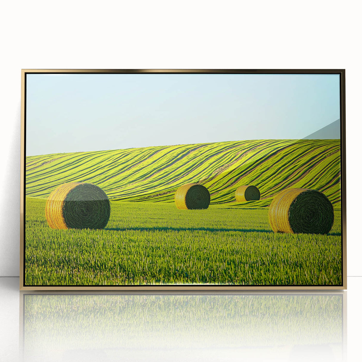 Framed acrylic artwork depicting a serene landscape field with lush green grass and a clear blue sky, featuring elegant gold accents for a sophisticated decor touch.