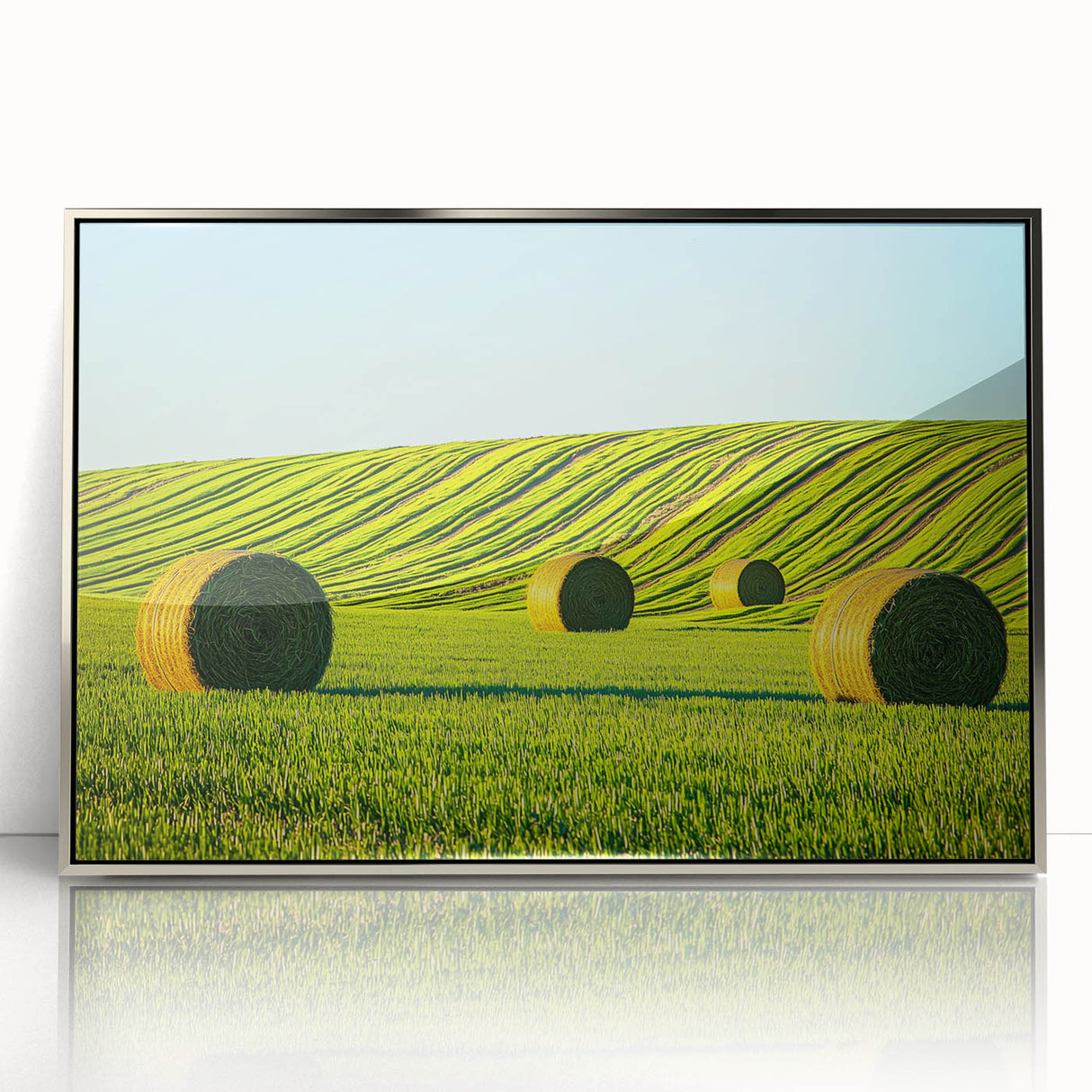 Framed acrylic artwork showcasing a serene landscape with lush green fields and a clear blue sky, elegantly designed for modern home decor.
