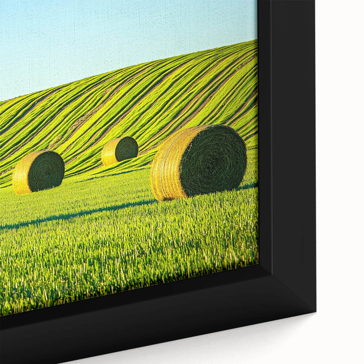 Close-up of a framed canvas print showcasing a vibrant landscape featuring lush green fields and a clear blue sky, perfect for home decor and art enthusiasts.