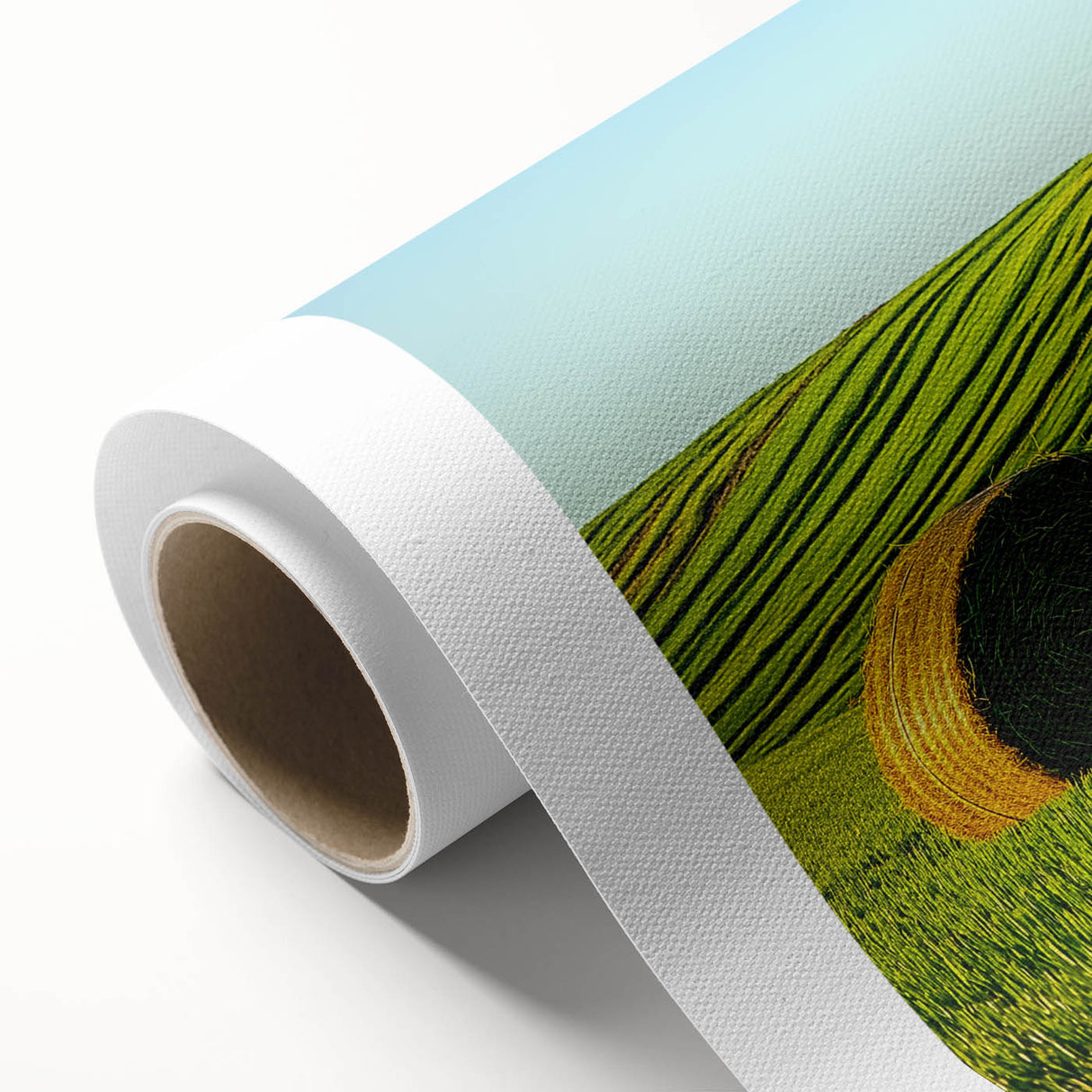 Vibrant rolled canvas artwork depicting a serene landscape of rolling fields under a blue sky, showcasing lush green hues and golden wheat, perfect for home decor.