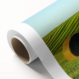 Vibrant rolled canvas artwork depicting a serene landscape of rolling fields under a blue sky, showcasing lush green hues and golden wheat, perfect for home decor.