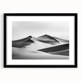 Framed landscape art print depicting serene sand dunes in a minimalist black frame, accented with a white mat, perfect for modern home decor.