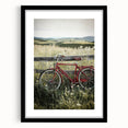 Framed landscape artwork depicting a serene countryside scene, featuring a sleek black frame and a white mat, ideal for home decor enhancement.