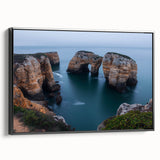 Framed canvas artwork showcasing a serene landscape with dramatic cliffs and a vibrant sunset, presented in a sleek black frame, ideal for home decor.