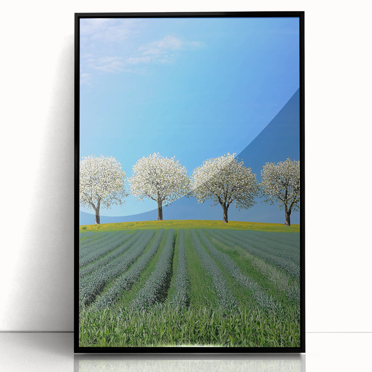 Framed acrylic artwork showcasing a vibrant landscape with rolling green fields and a clear blue sky, presented in a sleek black frame, ideal for modern home decor.