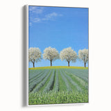 Framed canvas artwork showcasing a vibrant landscape of fields in soft pastel hues, displayed with a white border, perfect for home decor and artistic ambiance.