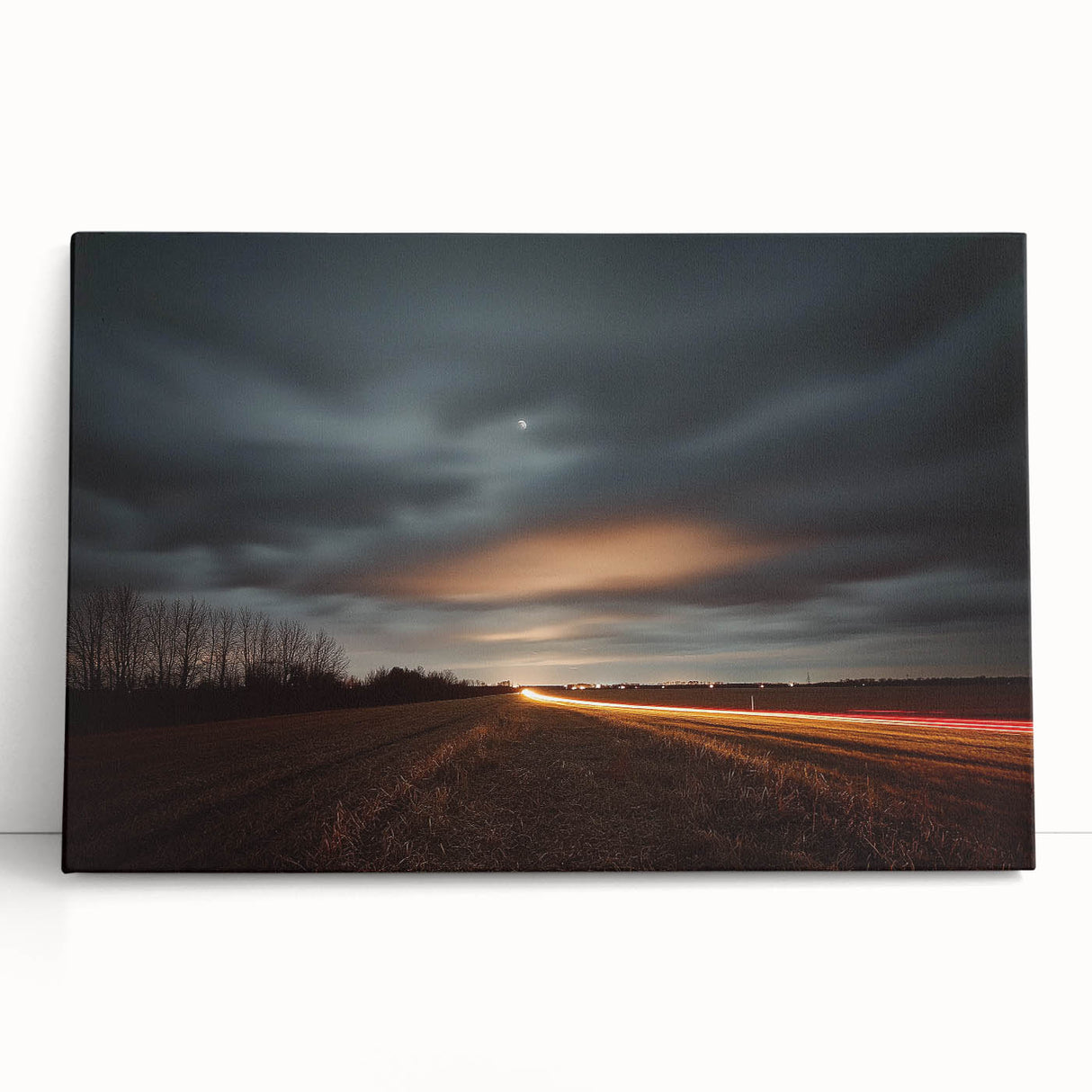 Stretched canvas art depicting a serene countryside landscape with rolling hills and vibrant greenery, leaning against a textured wall, perfect for home decor.