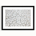 Black-framed landscape artwork depicting a serene desert scene, featuring warm earth tones and intricate details, ideal for home decor or office aesthetics.