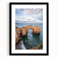 Framed black landscape artwork showcasing dramatic cliffs against a serene sky, enhancing home decor with a sophisticated touch and elegant matting.