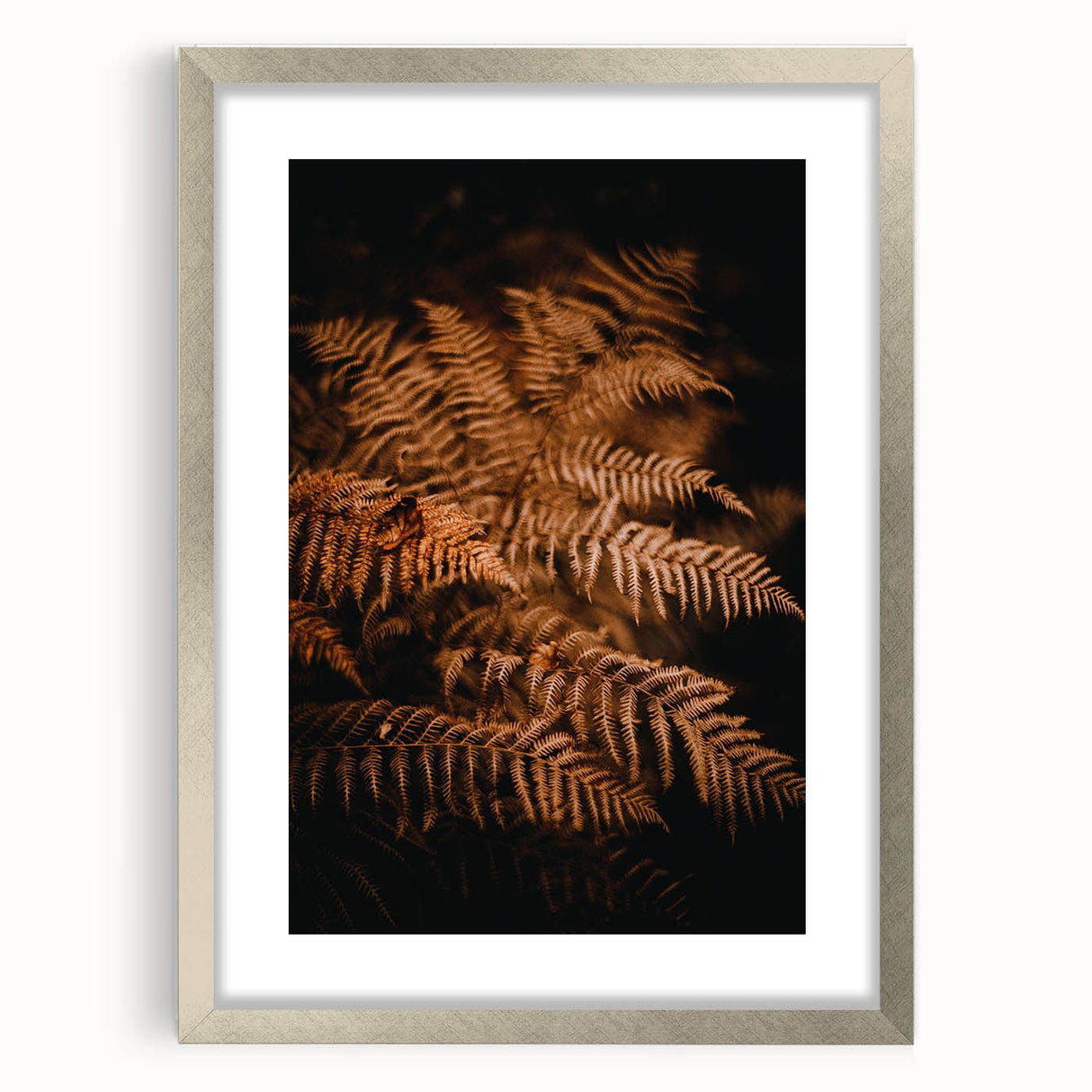 Textured abstract art print of autumn leaves in earthy tones on a framed silver mat, suitable for bedroom decor.