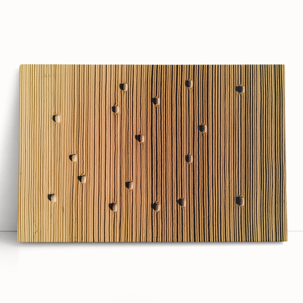 Stretched canvas artwork depicting a vibrant countryside landscape with rolling hills and a bright blue sky, leaning against a wall, showcasing rich colors and serene nature.