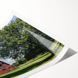 Rolled print showcasing a vibrant landscape of a rustic barn set against a blue sky, featuring rich colors and intricate details, ideal for home decor.