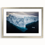 Framed landscape artwork showcasing dramatic cliffs under a vibrant sunset, featuring a silver mat and frame that enhances its elegance, perfect for home decor.