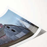 Rolled landscape print of a rustic barn scene, showcasing vibrant colors and detailed texture, securely packaged in a protective cardboard tube for safe delivery.