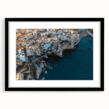 Framed landscape artwork showcasing dramatic cliffs against a vibrant sunset, presented in a sleek black frame with a white mat, perfect for modern decor.